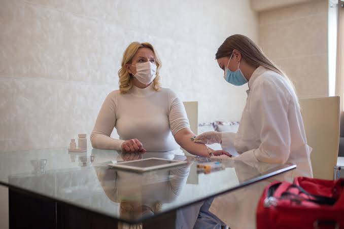 Profissional realizando coleta de sangue em domicílio